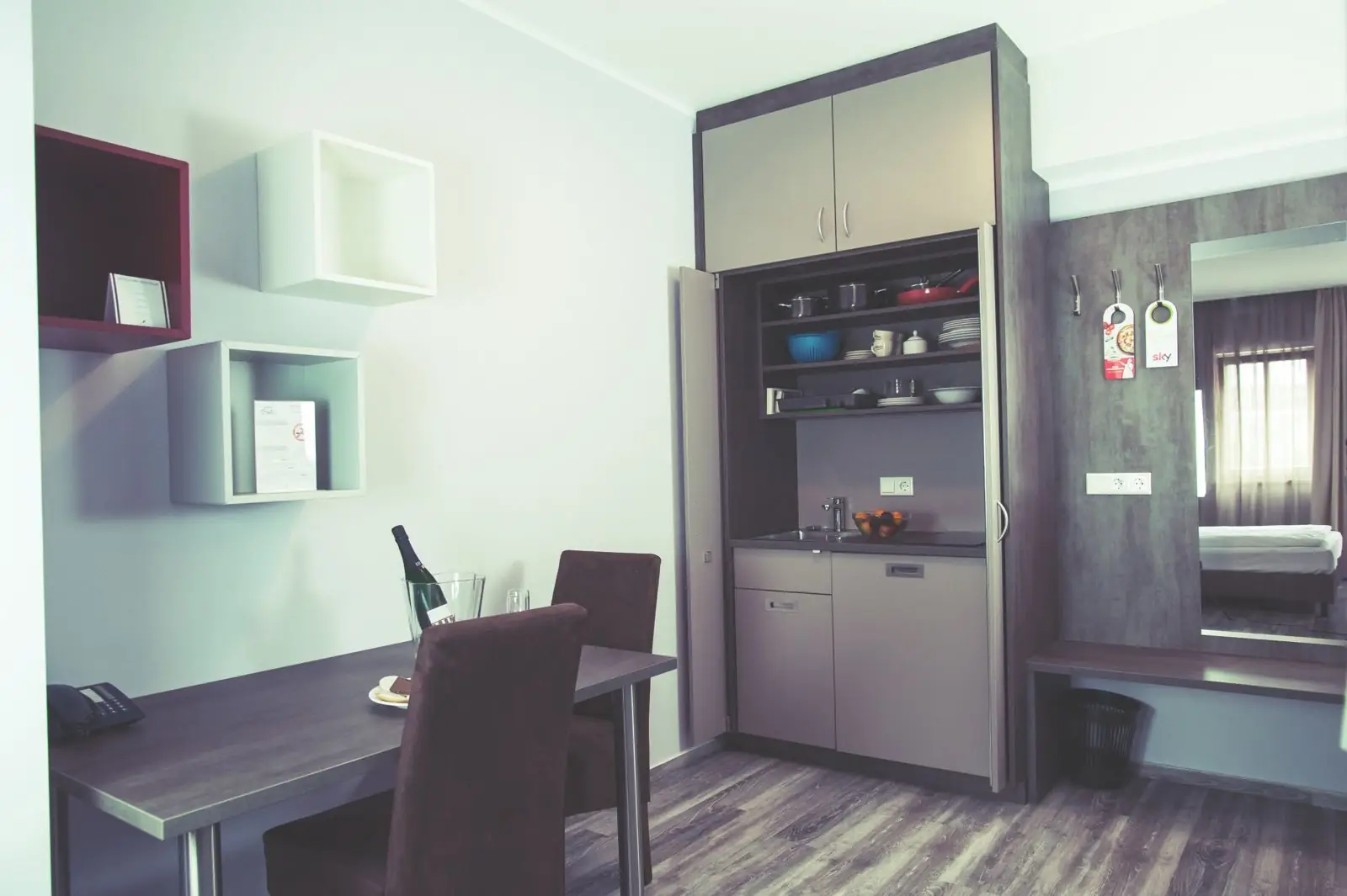 Aufgeräumtes Zimmer mit Schreibtisch und Kitchenette
